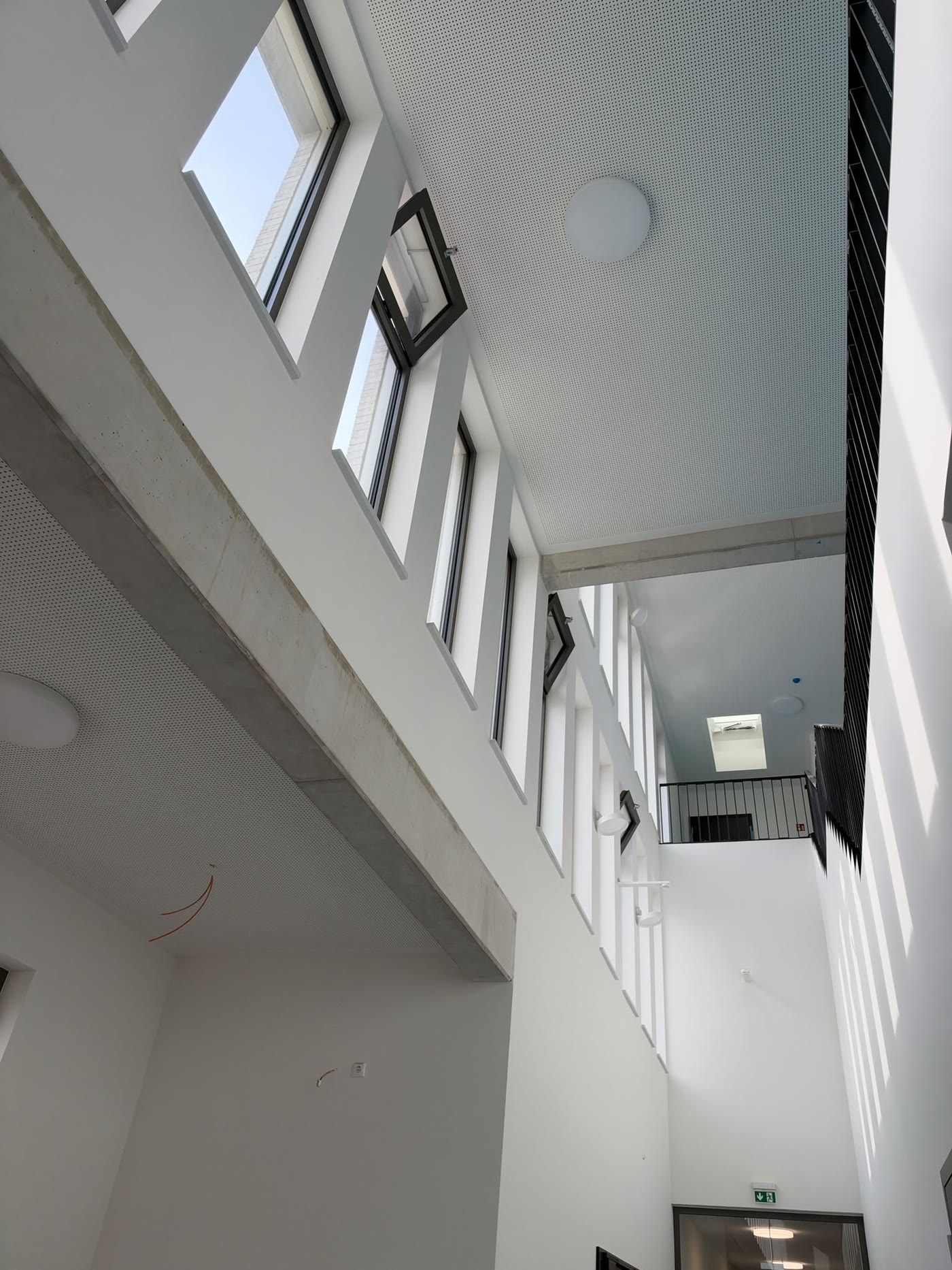 Heller, weiß verputzter Lichthof im Amtsgericht Eschweiler mit Oberlichtern und Galerie